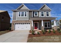 Charming two-story home boasts stone accents, a two-car garage, and a welcoming front porch at 8625 Bridgegate Dr, Huntersville, NC 28078