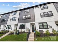 Modern townhome showcases black and white siding, black trim windows, and well-manicured lawn at 8723 Nolley Ct, Charlotte, NC 28270