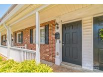 Charming brick townhouse entrance with black front door, mailbox and decorative exterior lighting at 1215 Green Oaks Ln # H, Charlotte, NC 28205