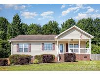 Charming single-story home featuring a covered front porch and well-maintained landscaping at 1221 Woodpecker Dr, Clover, SC 29710
