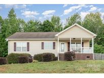 Charming single-story home with a welcoming front porch and well-maintained landscaping at 1221 Woodpecker Dr, Clover, SC 29710