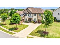 A beautifully landscaped two-story home with a long drive and attached two-car garage at 13204 Feale Ct, Charlotte, NC 28278
