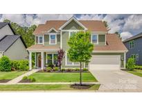 Charming two-story home boasts lush landscaping, a welcoming front porch, and a two-car garage at 155 Boxelder Rd, Clover, SC 29710