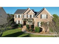 Beautiful two story brick home with well-maintained landscaping and dark shutters at 1708 Aringill Ln, Matthews, NC 28104