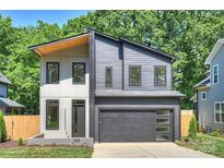 Modern two-story home with a gray exterior, a two-car garage and manicured landscaping at 1711 Summey Ave, Charlotte, NC 28205