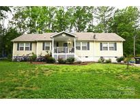 Charming single-story home featuring a covered porch and well-maintained front lawn with flower beds at 1821 Sherrer Rd, York, SC 29745