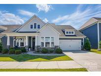 Charming two-story home with a manicured lawn, covered porch, and a two-car garage at 2062 Nellies Way, Fort Mill, SC 29715