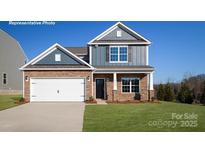 Charming two-story home featuring a two-car garage, stone accents, and a neatly manicured front lawn at 227 Paige Rd, Kings Mountain, NC 28086