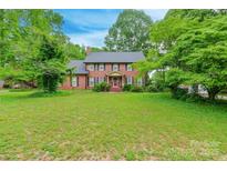 Beautiful two-story brick home with a lush green lawn and mature trees creating a serene setting at 2330 Raven Dr, Rock Hill, SC 29732