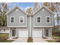 Charming two-story townhome with a two-car garage, neutral siding, and well-manicured landscaping at 2818 Old Steele Creek Rd, Charlotte, NC 28208
