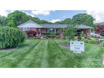 Charming brick home with beautifully landscaped front yard and manicured lawn at 3008 Imperial Dr, Gastonia, NC 28054