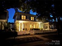 Charming two-story home with a welcoming front porch, picket fence, and illuminated by warm lights at twilight at 330 Horton Grove Rd, Fort Mill, SC 29715