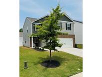 Charming two-story home featuring brick and vinyl siding, complemented by a well-manicured lawn and inviting front yard landscaping at 446 Misty Law Ln, Clover, SC 29710