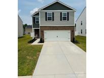 Charming two-story home with a spacious driveway, manicured lawn, and brick and vinyl siding at 446 Misty Law Ln, Clover, SC 29710