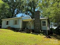 Charming, light blue single-Gathering home with stone chimney and well-maintained front yard at 66 Arlington Se Ave, Concord, NC 28025