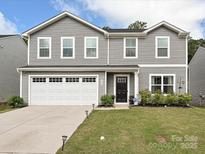 Charming two-story home featuring vinyl siding, a well-maintained lawn, and a two-car garage at 665 Pointe Andrews Dr, Concord, NC 28025