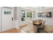 Inviting dining room boasts a modern chandelier, stylish decor, and a view of the landscaped outdoors at 7105 Butternut Oak Ter, Huntersville, NC 28078