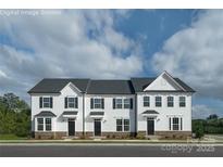 New white townhome exteriors feature a gray roof, stone accents, and black shutters at 7631 Griffins Gate Sw Dr, Concord, NC 28025