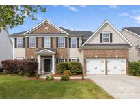 Charming two-story home with brick and siding, well-manicured lawn, and a two-car garage at 9647 Laurie Nw Ave, Concord, NC 28027