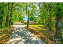 Brick ranch home with mature trees, long driveway, and inviting curb appeal at 1154 Doby Ct, Fort Mill, SC 29715