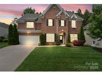 Beautiful two-story brick home featuring a well-manicured lawn and an attached two-car garage at 15247 Prescott Hill Ave, Charlotte, NC 28277