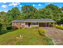 Charming single-story brick home with a welcoming front porch and a well-maintained, expansive front lawn at 157 E Meadowview Dr, Statesville, NC 28625