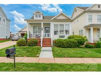 Charming two-story home with a inviting front porch, brick steps, landscaped yard, and a blue door at 23128 Goose Down Ln, Lancaster, SC 29720