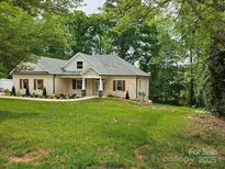 Beautiful brick home boasts a well-manicured lawn and lovely landscaping at 2442 Falcon Ln, Statesville, NC 28625
