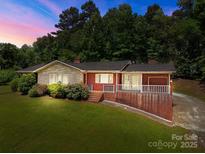 Charming brick home with stone accents, landscaped yard and a covered front porch perfect for relaxing at 24501 Canton Rd, Albemarle, NC 28001