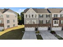 Charming townhome featuring a brick and siding exterior, well-manicured lawn, and a two-car garage with inviting curb appeal at 2665 Grantham Place Dr, Fort Mill, SC 29715