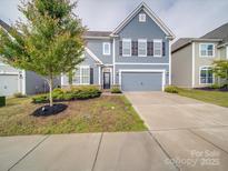 Charming two-story home with a well-maintained lawn, inviting curb appeal, and a two-car garage at 3022 Burnello Ct, Iron Station, NC 28080