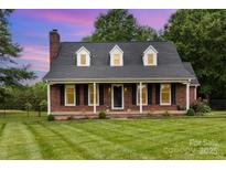 Charming brick home featuring a manicured lawn, black shutters and a covered porch in a quiet neighborhood at 3049 Stablegate Dr, Gastonia, NC 28052