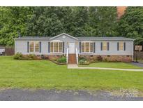 Charming single-story home with well-maintained lawn, brick foundation and inviting front porch at 403 Carpenter Parker Ln, Rock Hill, SC 29730