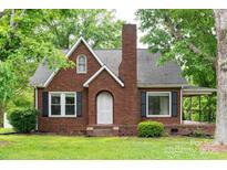 Charming brick home featuring a gabled roof, black shutters, and a cozy front porch at 4098 S Nc Hwy 127 Hwy, Hickory, NC 28602