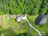 Beautiful aerial view of estate home with pond, acreage and mature trees at 4111 Jenkins Rd, Marshville, NC 28103