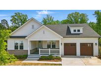 Charming home featuring a covered porch, two-car garage, and professionally landscaped yard at 4116 Spring Cove Way, Belmont, NC 28012