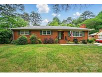 Charming single-story brick home featuring a well-maintained lawn and traditional green shutters at 4220 Castlewood Rd, Charlotte, NC 28209