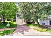 Charming two-story home with a well-maintained lawn, mature trees, and a private driveway leading to an attached garage at 459 Presidents Ct, Charlotte, NC 28217