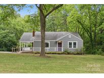 Charming gray home with a welcoming porch, set amidst lush greenery and mature trees at 500 Peigler Nw St # Lots 1 & 2, Concord, NC 28027