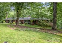 Charming brick home featuring a manicured lawn, mature trees, and classic architectural details at 507 Richards Dr, Shelby, NC 28150