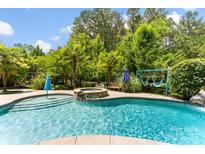 Inviting backyard pool and spa surrounded by lush greenery creates a private and relaxing oasis at 5418 Commodore Pl, Clover, SC 29710