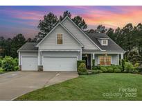 Charming home with three-car garage, manicured lawn, and beautiful sunset backdrop at 6309 Fawn Crest Dr, Waxhaw, NC 28173