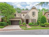 Charming home with stone accents, lush landscaping, and a pergola-covered garage in a desirable neighborhood at 6831 Conservatory Ln, Charlotte, NC 28210
