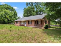 Classic single-story brick home with black shutters and a covered porch at 804 Gw Broome Rd, Monroe, NC 28112
