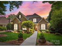 Charming brick home with lush landscaping and a beautiful walkway leading to the front door at 8701 Highgrove St, Charlotte, NC 28277
