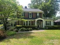 Charming two-story brick home with black shutters, a manicured lawn, and lush landscaping at 1139 S Belvedere Ave, Gastonia, NC 28054