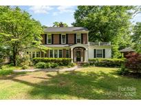 Charming brick home with a manicured lawn, lush greenery, and a quaint front porch at 1139 S Belvedere Ave, Gastonia, NC 28054