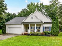 Charming single-story home with a manicured lawn, covered porch, and attached two-car garage at 11647 Baystone Pl, Concord, NC 28025