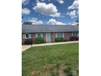 Charming brick townhouse with a well-manicured lawn and lovely turquoise shutters and front door at 1326 5Th Ne St, Hickory, NC 28601