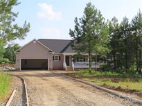 Charming single-Gathering home featuring a covered front porch and an attached two-car garage with gravel driveway at 153 Mason Tanner Ct, Rock Hill, SC 29730